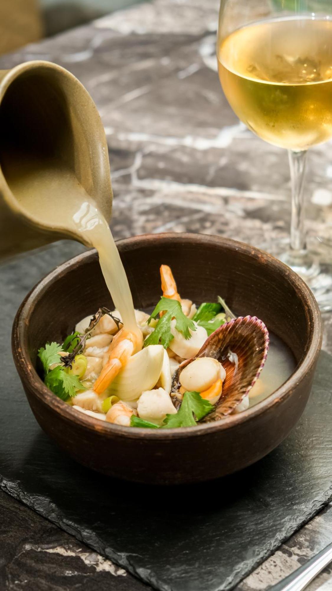 Pullman Santiago El Bosque Hotel Exterior foto Bouillon being poured into a bowl of seafood