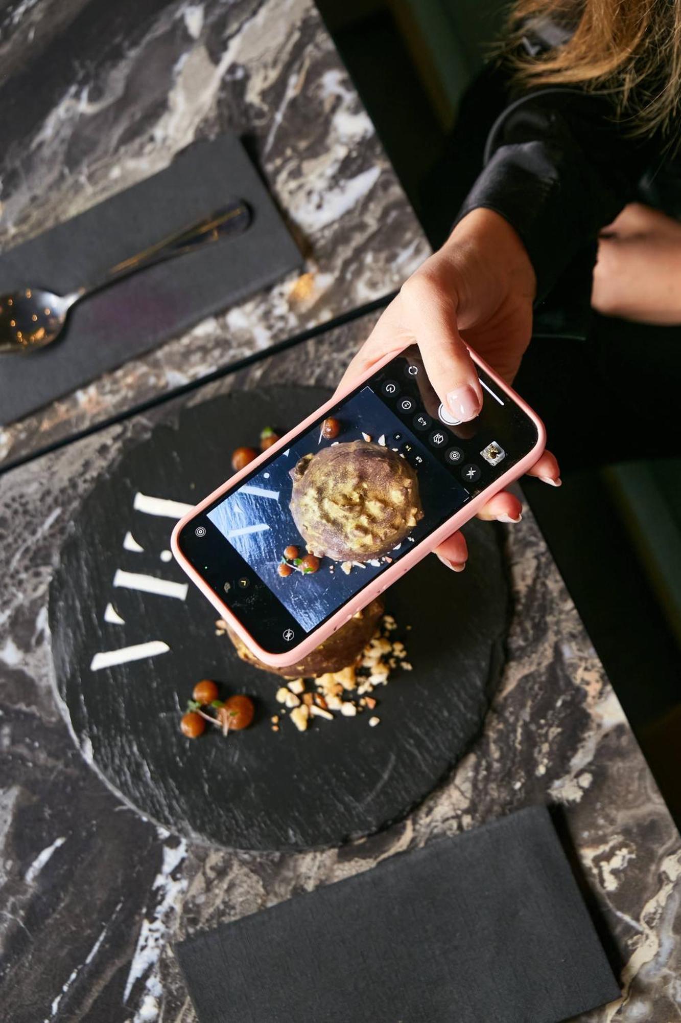 Pullman Santiago El Bosque Hotel Exterior foto A smartphone being used to take a photograph of a food item